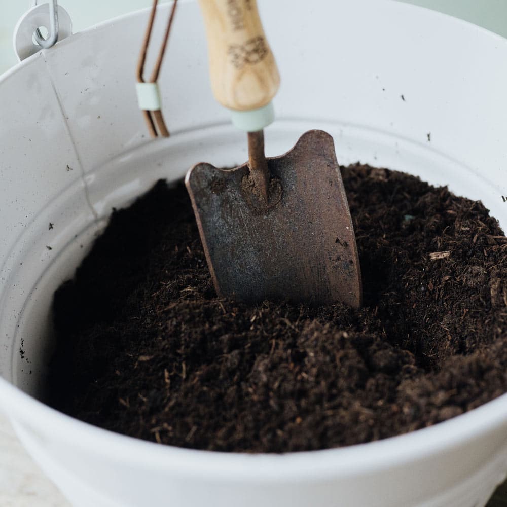 Eimer in weiß, Erde und Schaufel