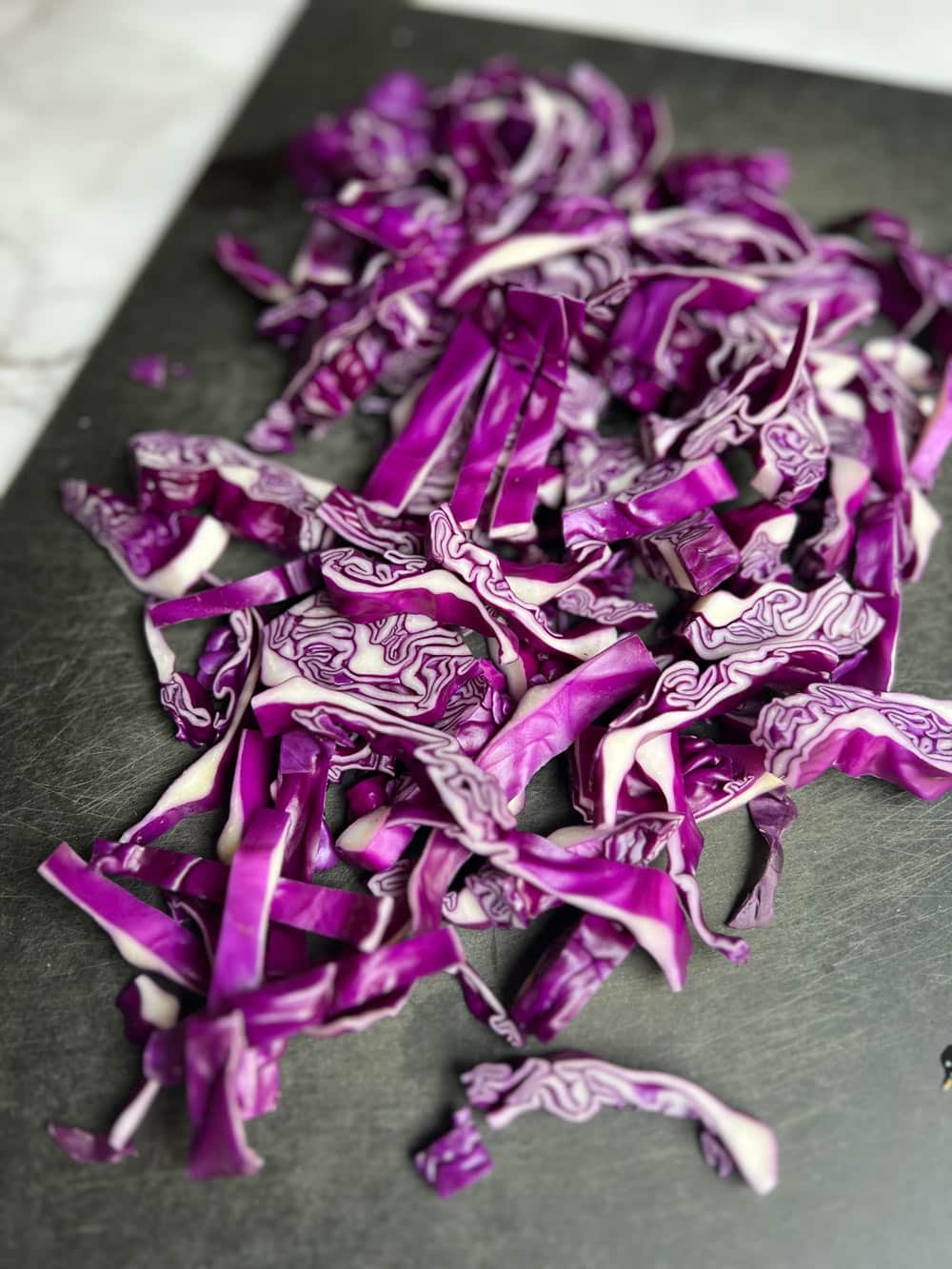 der lila Spitzkohl wird in Streifen geschnitten